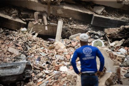 Una persona observa a una víctima entre los escombros de un edificio