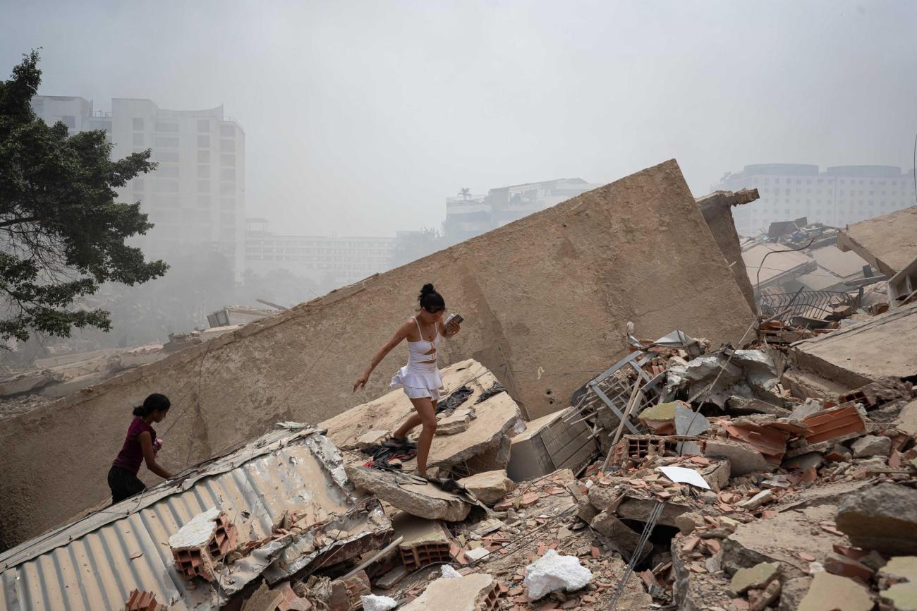 Personas caminan entre los escombros de edificios afectados