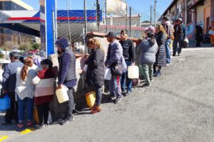 La gente hace larga filas para comprar combustible en bidones