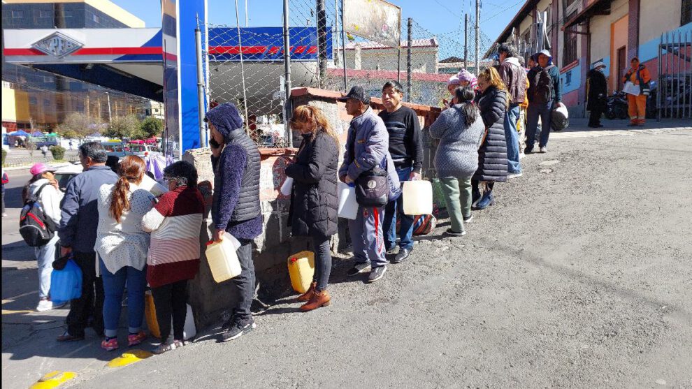 La gente hace larga filas para comprar combustible en bidones