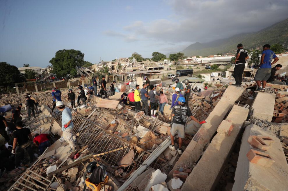Personas realizan labores de búsqueda en una zona afectada por los terremotos en Venezuela.