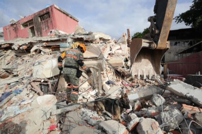 Un rescatista del Ejercito de México junto a su perro trabajan en un edificio afectado por los terremotos deñ pasado miércoles, en La Guaira (Venezuela).