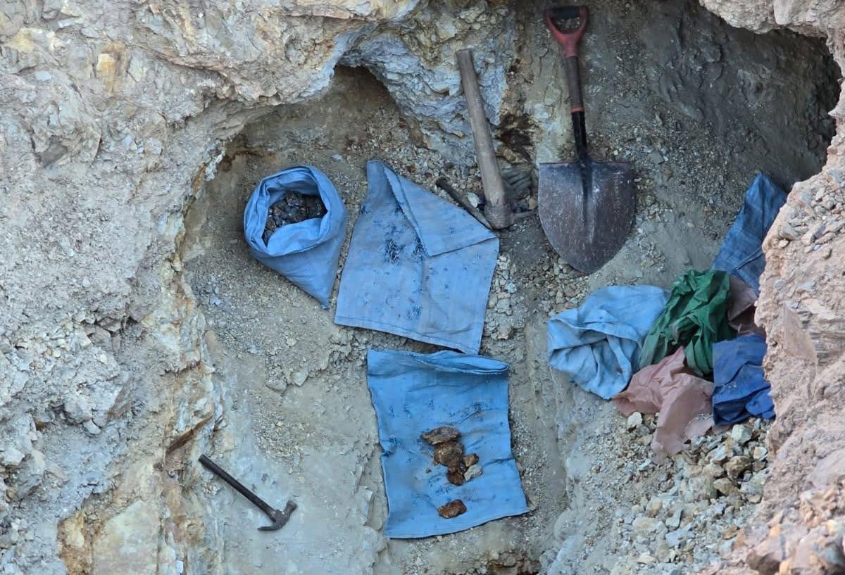 Las herramientas manuales y bolsas con material mineralizado