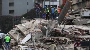 Equipos de rescate trabajan entre los escombros de edificios colapsados tras el doble terremoto