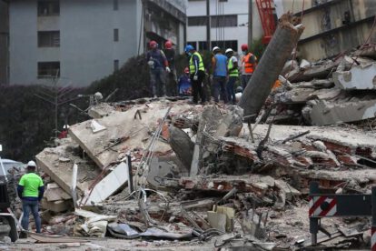 Equipos de rescate trabajan entre los escombros de edificios colapsados tras el doble terremoto