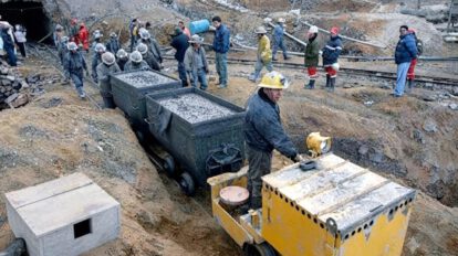 Minero operando una locomotora en la entrada de la mina