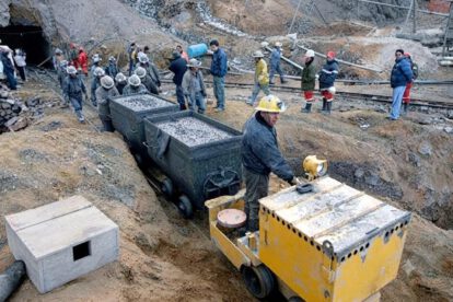 Minero operando una locomotora en la entrada de la mina