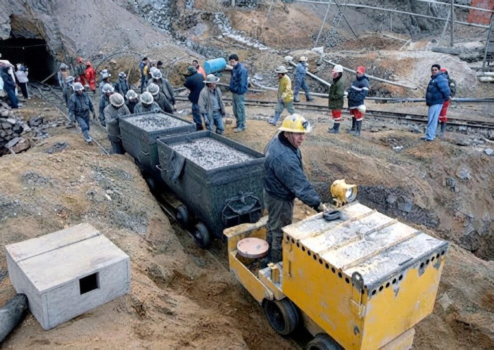 Minero operando una locomotora en la entrada de la mina
