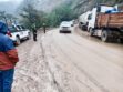 Personal policial  regulando el tráfico vehicular en una vía de lodo y tierra en la carretera