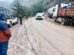 Personal policial  regulando el tráfico vehicular en una vía de lodo y tierra en la carretera