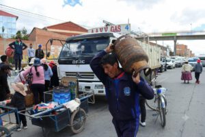 Un hombre carga una garrafa de gas sobre sus hombros