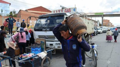 Un hombre carga una garrafa de gas sobre sus hombros