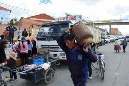 Un hombre carga una garrafa de gas sobre sus hombros