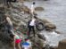 Migrantes usando flotadores caseros para cruzar por la zona rocosa de la costa