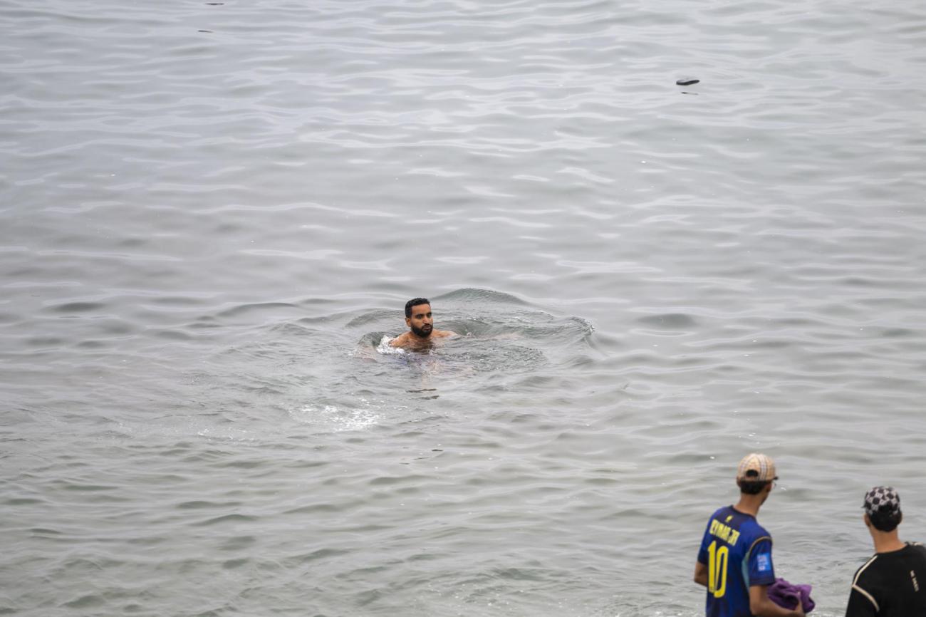 Un migrante intenta alcanzar la costa a nado entre el oleaje