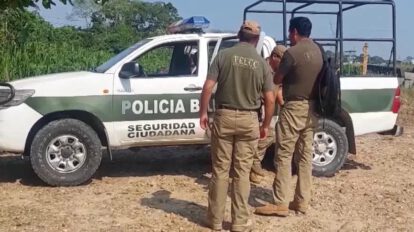 Dos personas y un auto de policia