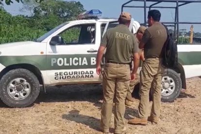 Dos personas y un auto de policia