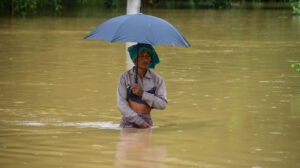 Un hombre camina entre el agua por las fuertes lluvias