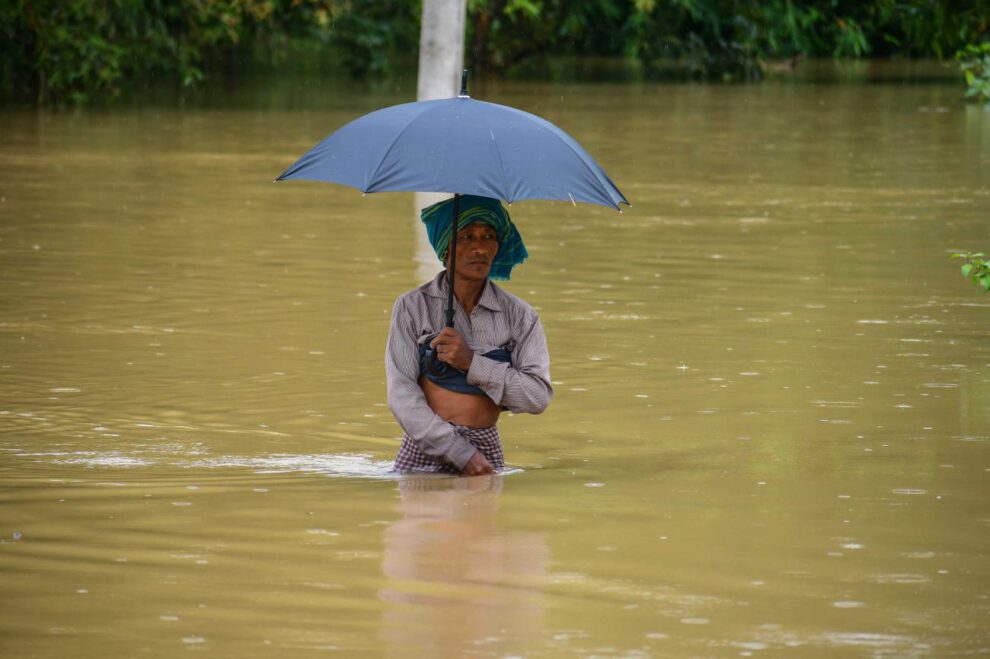 Un hombre camina entre el agua por las fuertes lluvias