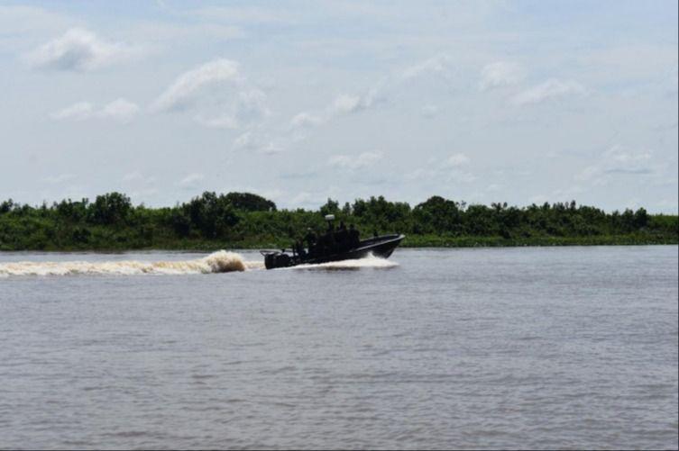 Soldados a bordo de una lancha patrullando el río