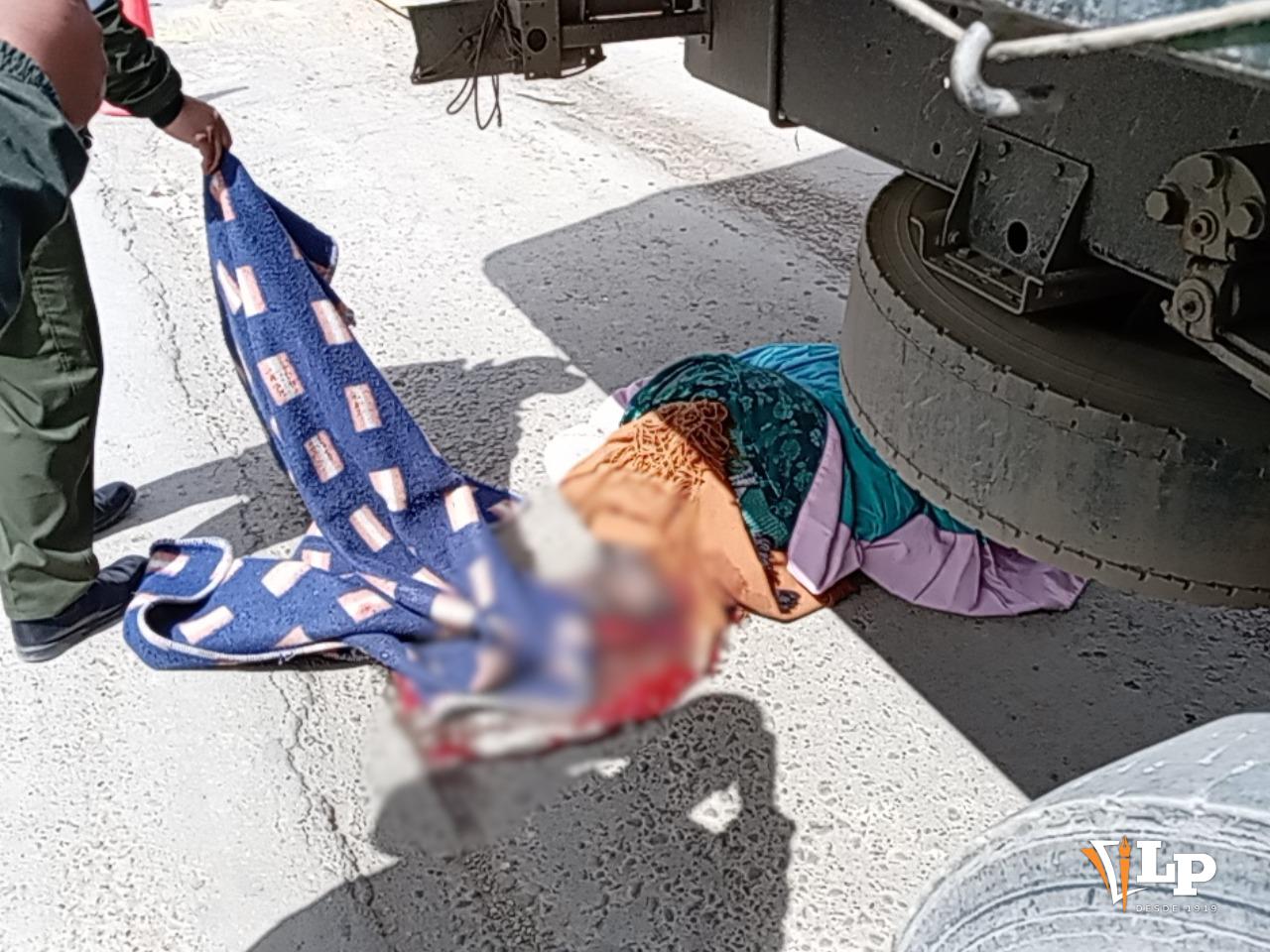 Efectivo policial cubriendo el cuerpo de la víctima