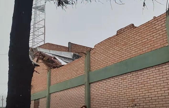El techo metálico corrugado retorcido y desplomado por la nieve
