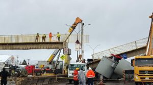 Grúas y personal de auxilio evalúan los daños en la estructura colapsada