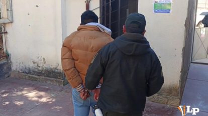 Un efectivo policial custodia al hombre aprehendido