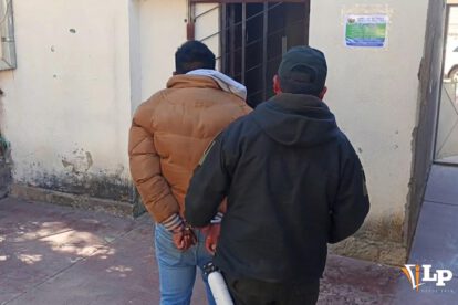 Un efectivo policial custodia al hombre aprehendido