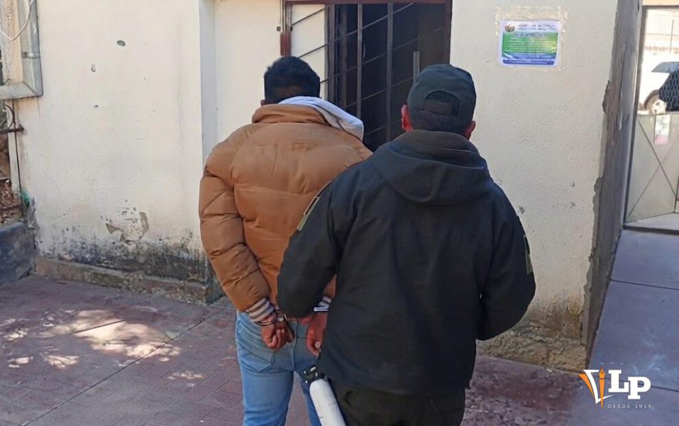 Un efectivo policial custodia al hombre aprehendido