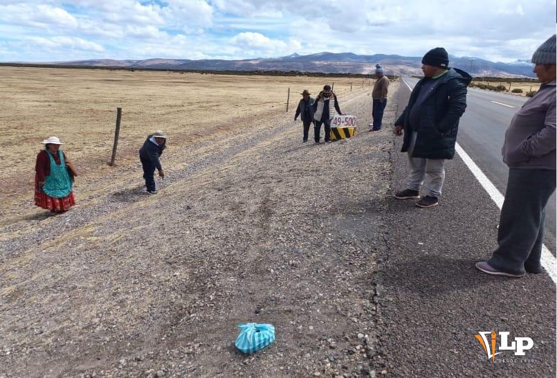Grupo de personas reunidas a un lado de la carretera