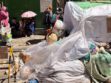 Contenedor de basura cubierto y personas