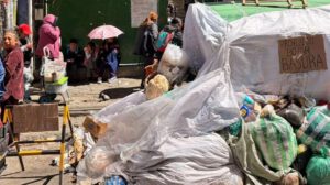Contenedor de basura cubierto y personas