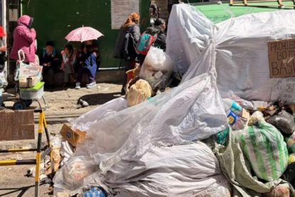 Contenedor de basura cubierto y personas