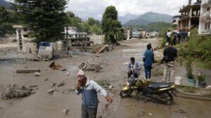 Los aldeanos atraviesan calles inundadas tras una inundación repentina en Trishuli Bazar, distrito de Nuwakot, Nepal,