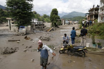 Los aldeanos atraviesan calles inundadas tras una inundación repentina en Trishuli Bazar, distrito de Nuwakot, Nepal,