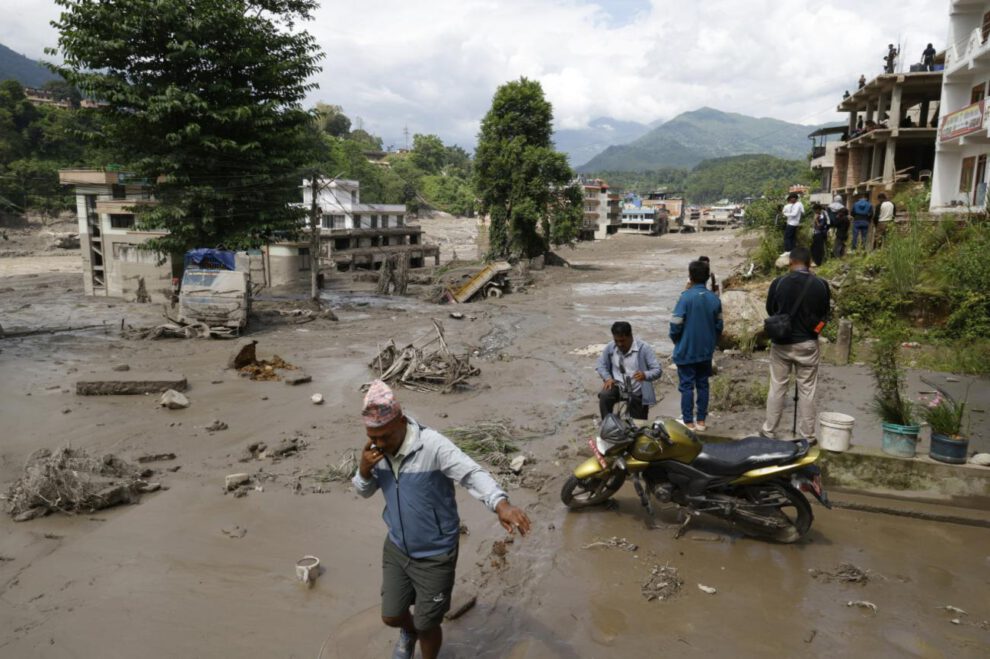 Los aldeanos atraviesan calles inundadas tras una inundación repentina en Trishuli Bazar, distrito de Nuwakot, Nepal,