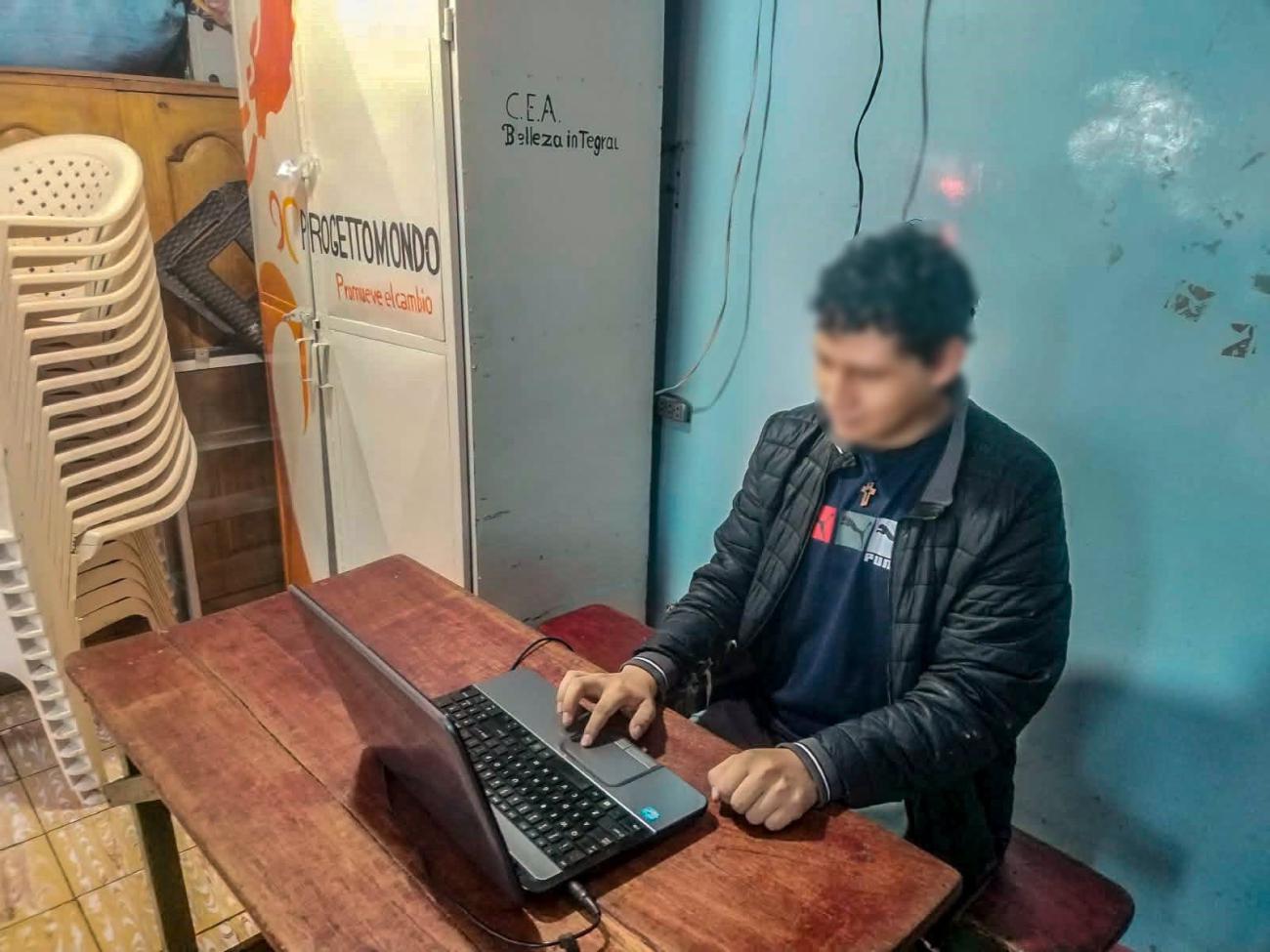 Un estudiante utilizando una computadora portátil en el interior de un recinto carcelario