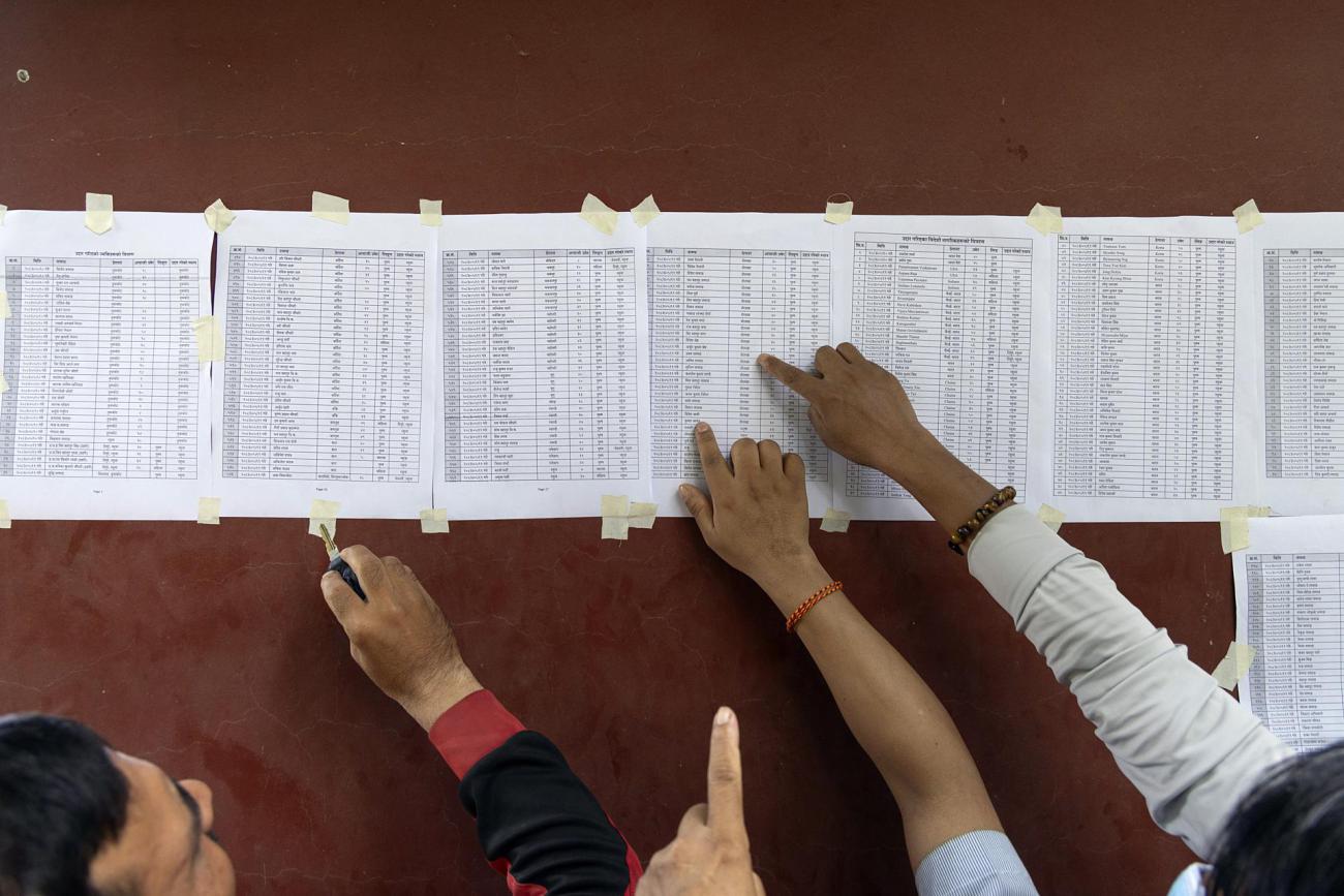 La gente busca los nombres de sus familiares en listas de personas desaparecidas
