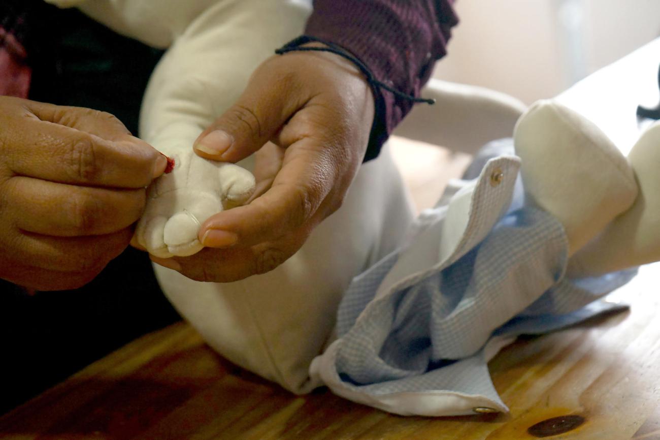 Una persona cosiendo un muñeco de tela
