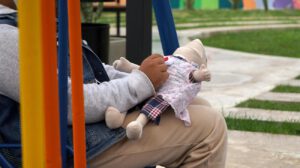 Una niña sosteniendo un muñeco de tela en Santa Cruz