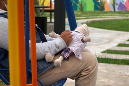 Una niña sosteniendo un muñeco de tela en Santa Cruz