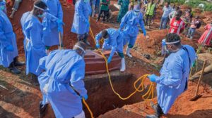 Personal sanitario con equipo de protección realiza un entierro