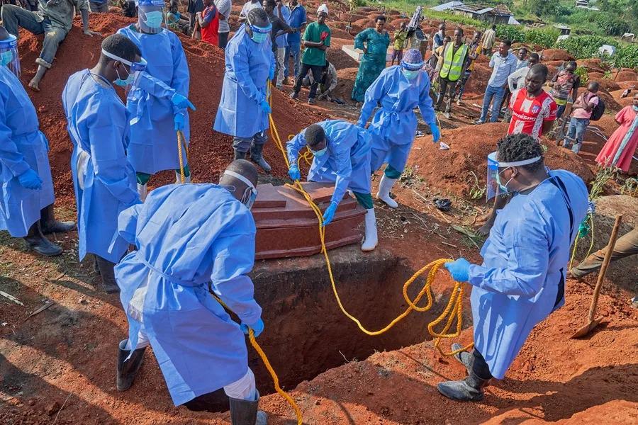 Personal sanitario con equipo de protección realiza un entierro