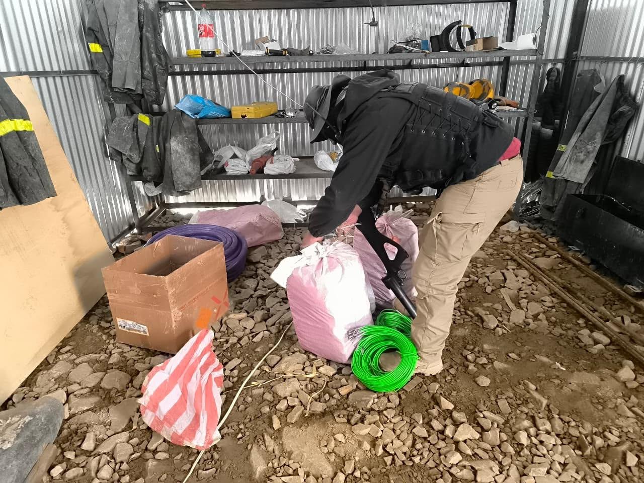 Autoridades revisando los suministros y materiales hallados en el campamento minero