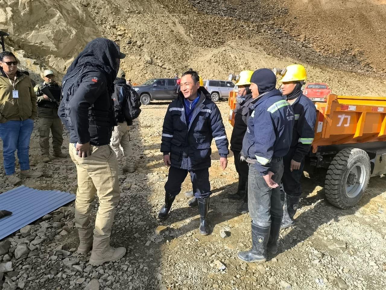 Personal de seguridad dialogando con algunos de los detenidos en el campamento minero