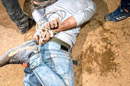 Un hombre yace en el suelo maniatado de pies y manos