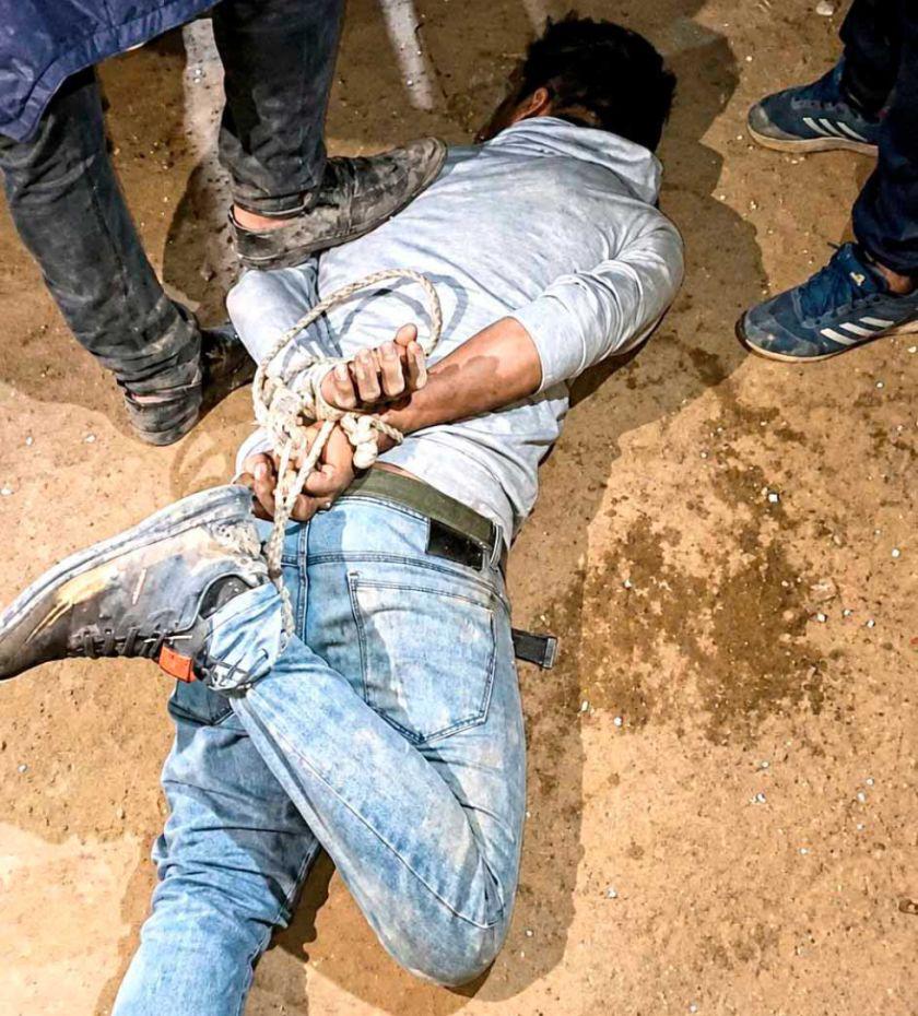 Un hombre yace en el suelo maniatado de pies y manos