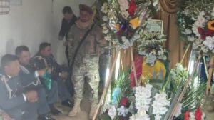Velorio donde familiares y miembros del ejército acompañan un féretro
