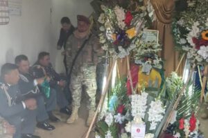 Velorio donde familiares y miembros del ejército acompañan un féretro